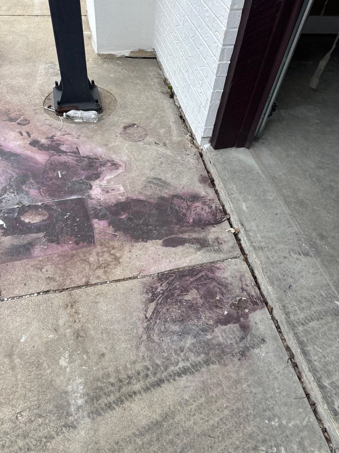 Heavily stained concrete walkway at a Pendleton home before cleaning