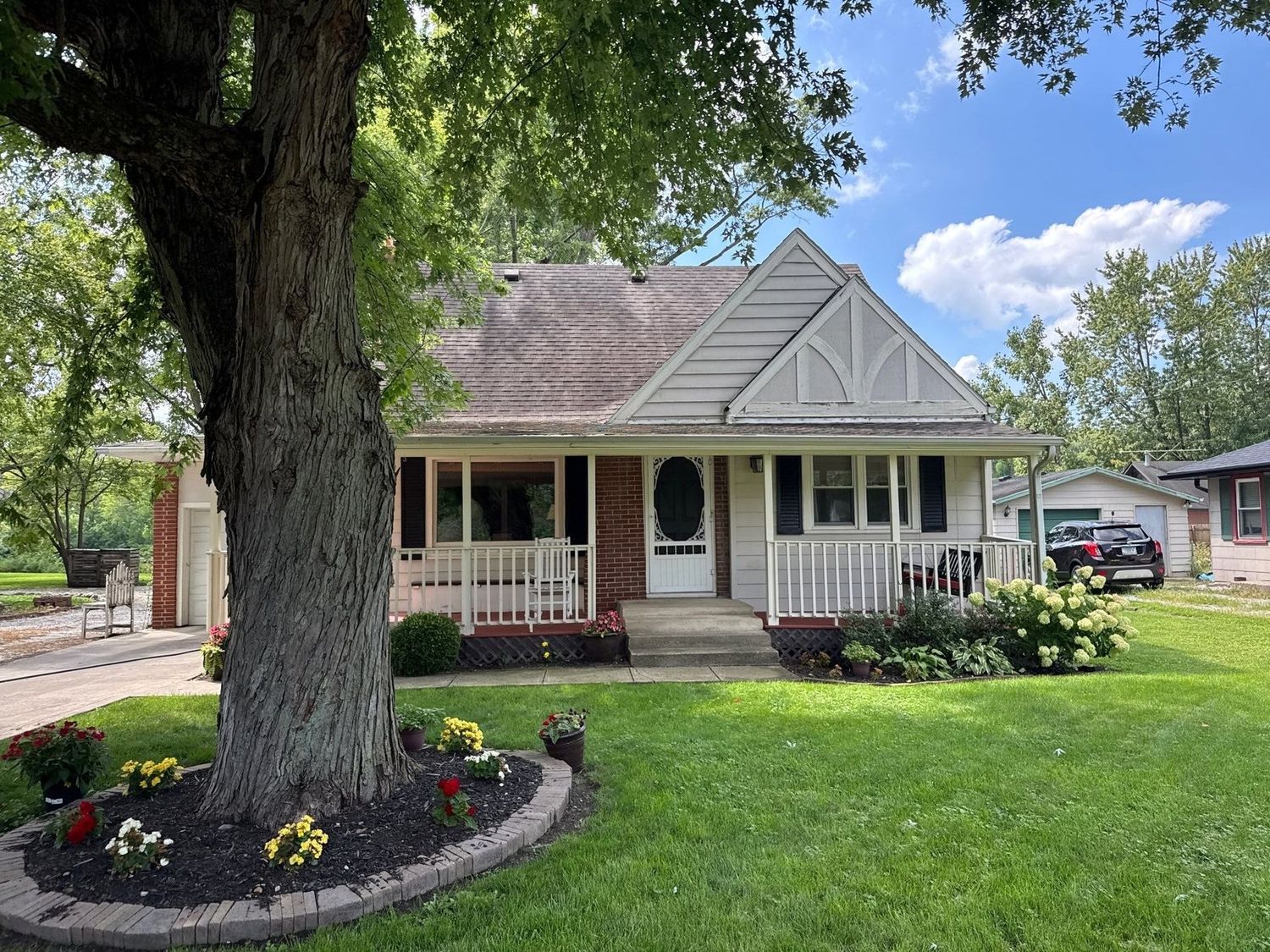 Anderson home behind a mature oak and a planted bed after exterior cleaning