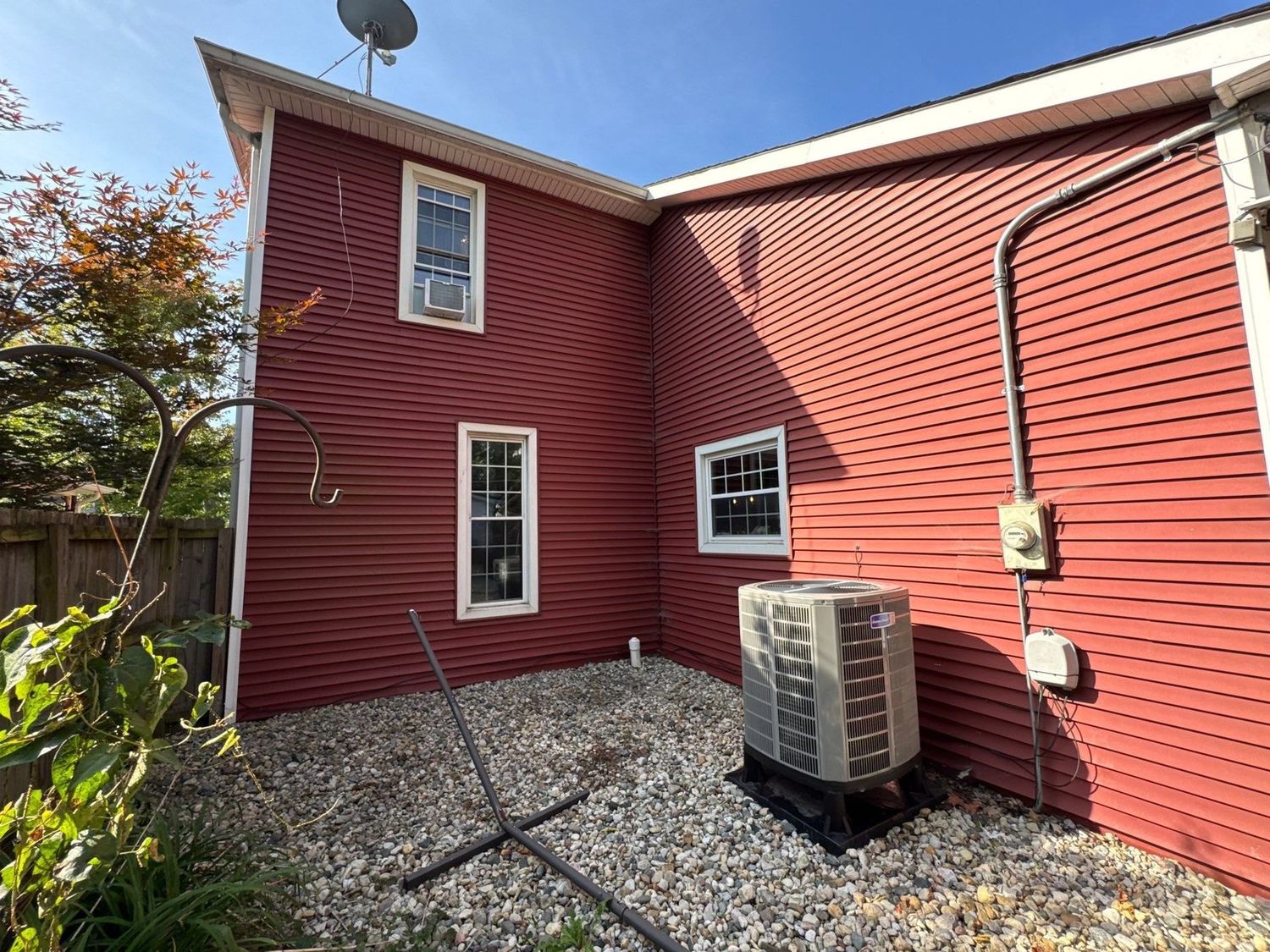Red sided Noblesville home after a soft wash, gravel bed along the foundation
