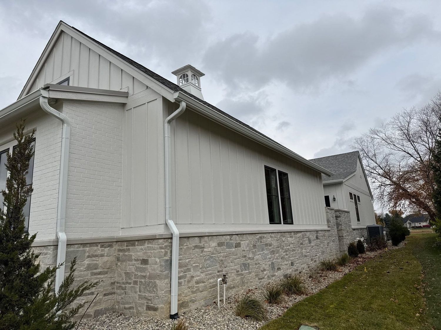 Noblesville home in white siding and stone after a soft wash