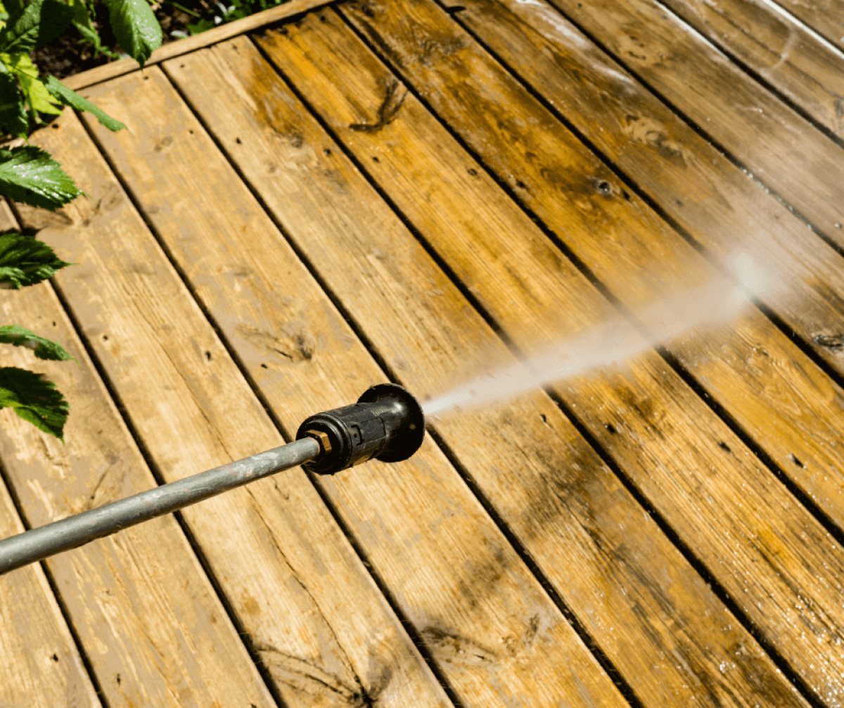 Close view of a wand lifting gray off weathered deck boards
