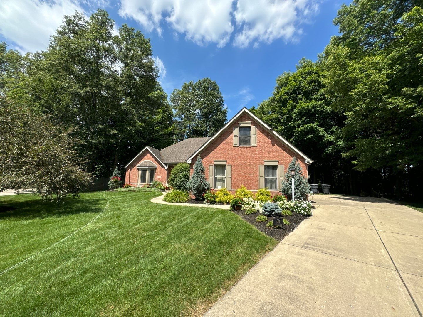 Brick Indiana home with a clean concrete drive running to the street