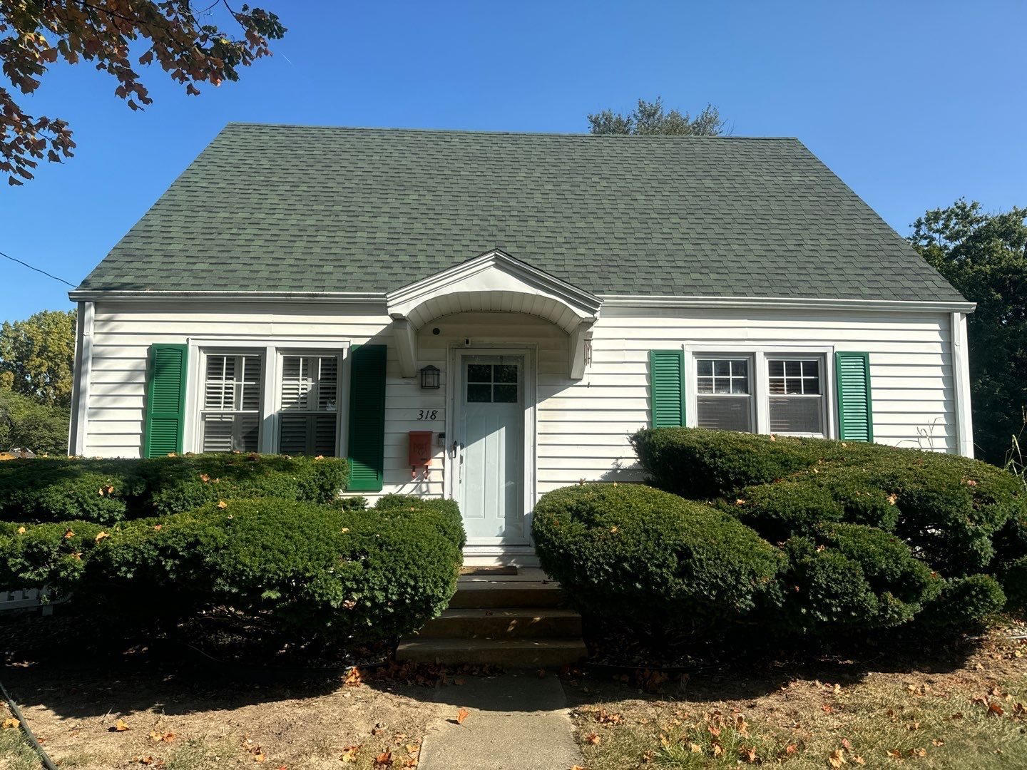 White sided Indiana home with green shutters after an exterior house wash